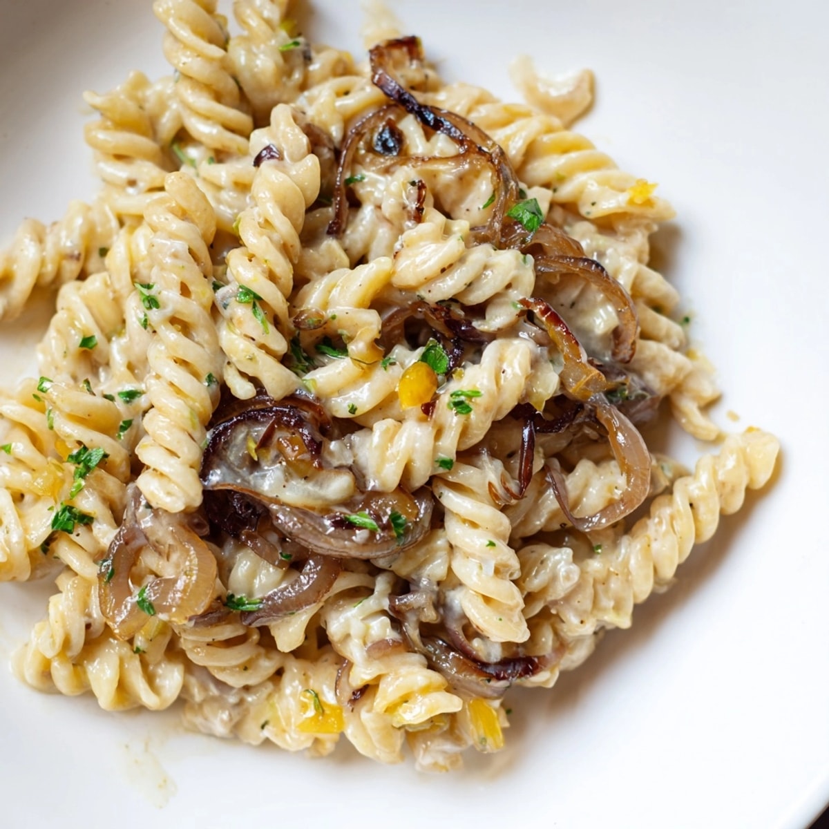 Closeup of golden OnePot French Onion Pasta steam rises promising rich savory flavors.