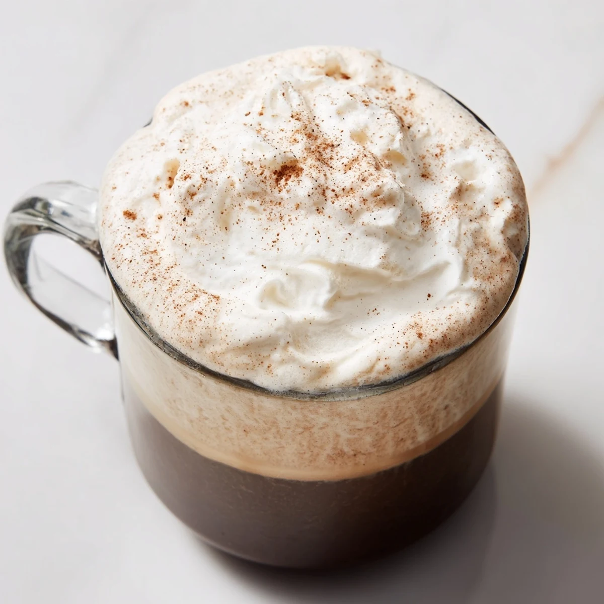 A warm mug of Spiced Latte, garnished with whipped cream and dusted with nutmeg.