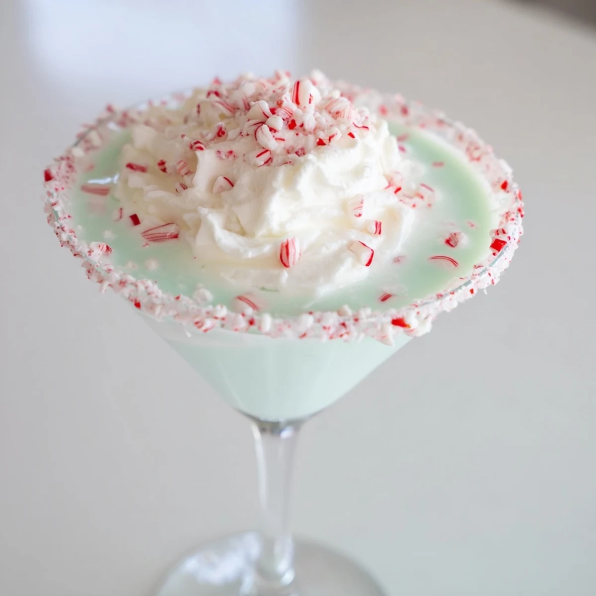 A frosted martini glass filled with a creamy, pale pink Peppermint Twist cocktail.
