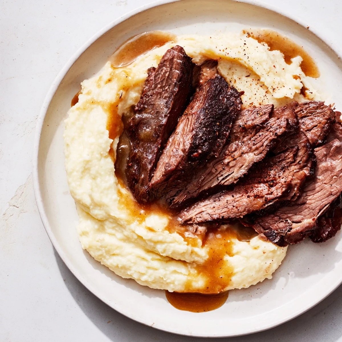 A close-up of the delicious beef brisket recipe with flavorful gravy and sweet potato, ideal for sharing.