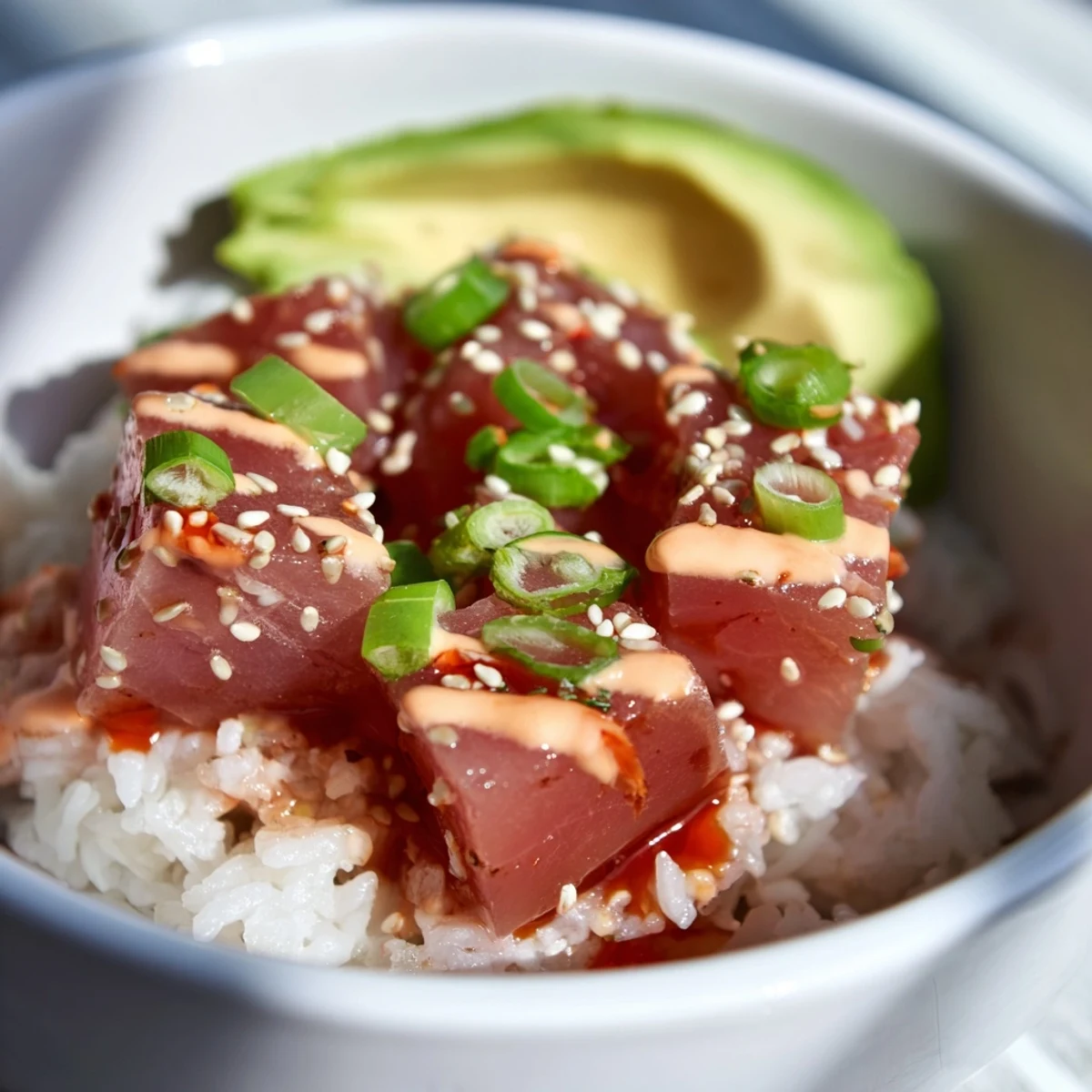 Close-up of a vibrant Spicy Tuna Poke Bowl with Sriracha Mayo, featuring fresh tuna cubes and creamy sauce.