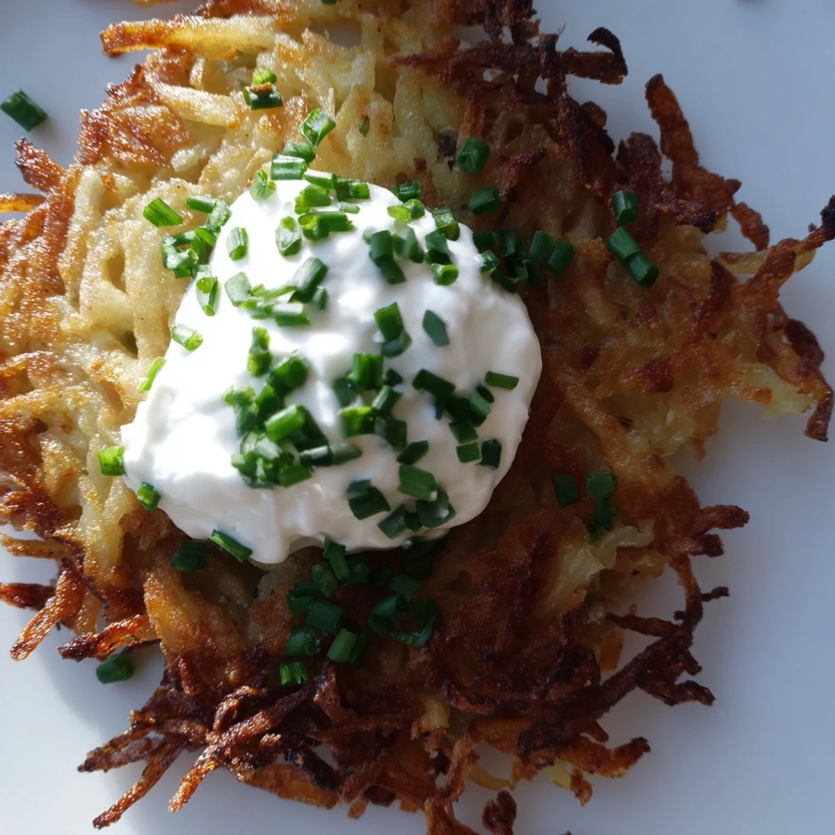 Homemade Crispy Potato Latkes with tender centers, served with creamy dip on a festive holiday platter.