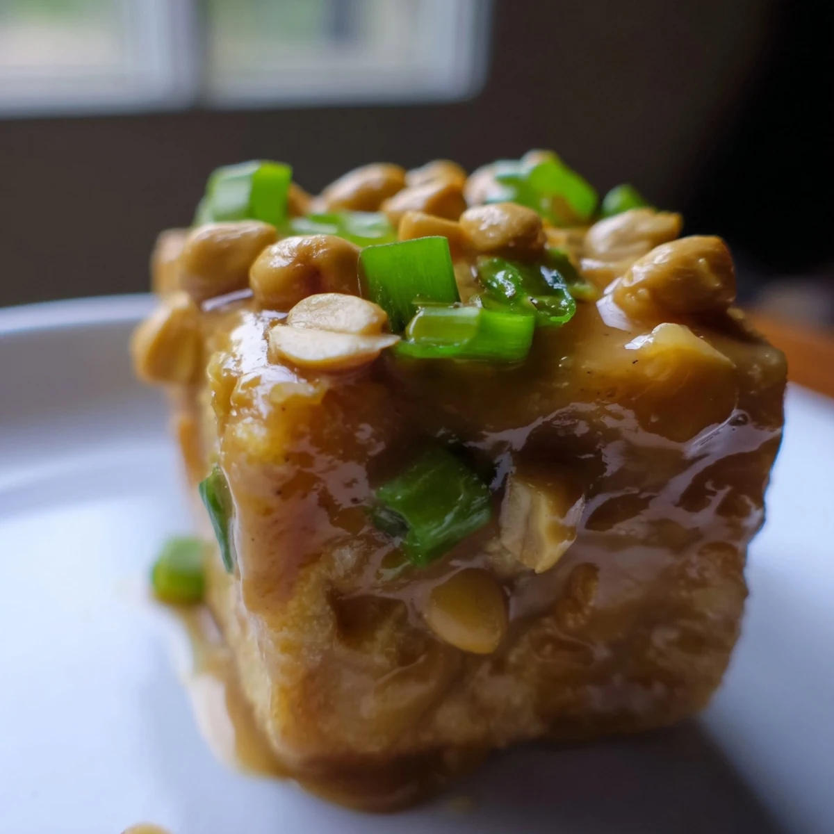 Close-up of golden Air Fryer Crispy Tofu with Peanut Sauce, highlighting the crunchy texture and drizzled dressing.