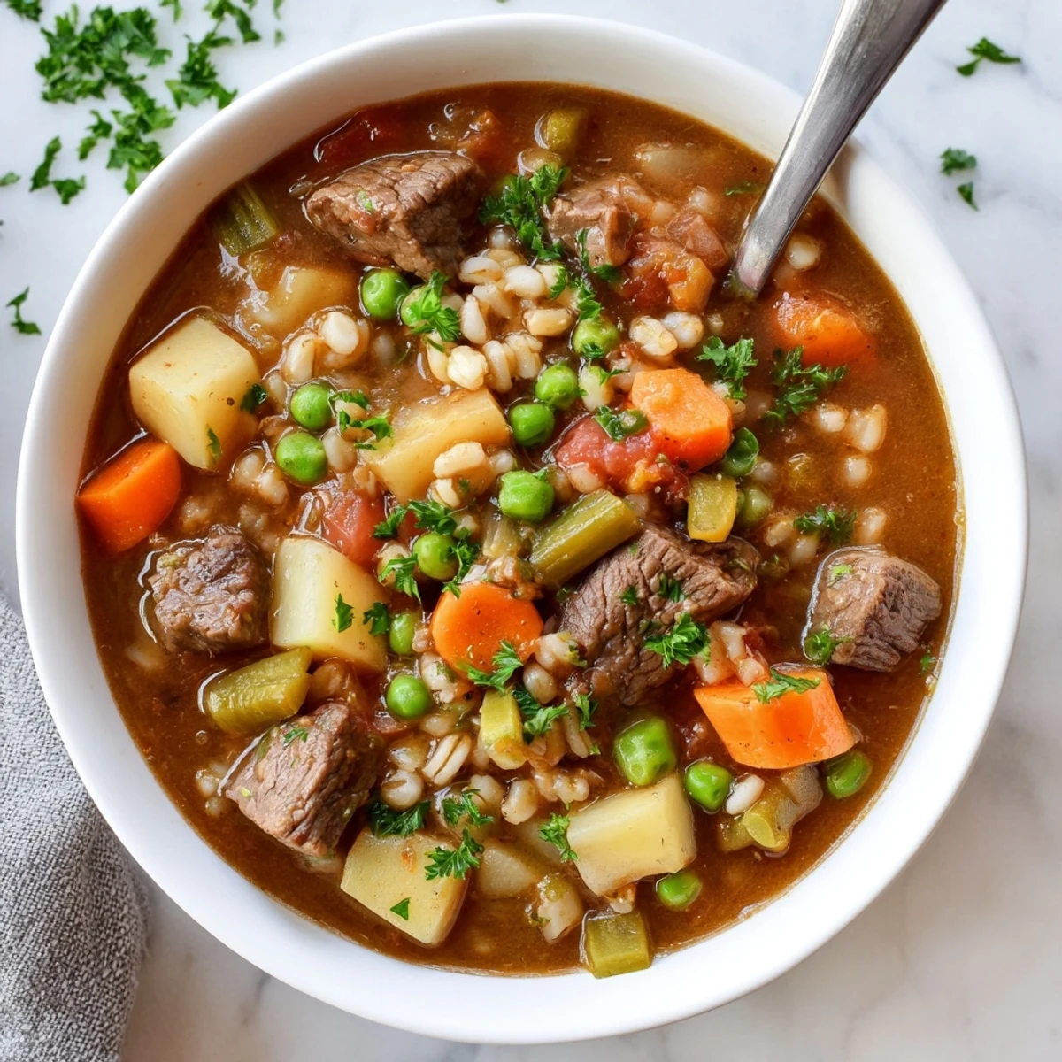 Close-up of Hearty Beef and Barley Vegetable Stew with visible potatoes, carrots, and beef chunks, steam rising from the thick, nourishing broth.