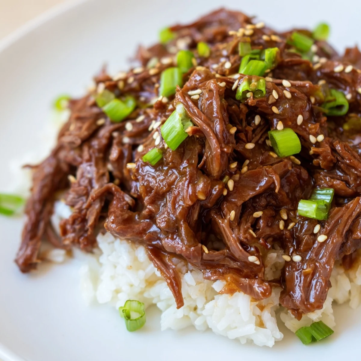 Crock Pot Korean Beef simmering in a rich, glossy sauce in the slow cooker.