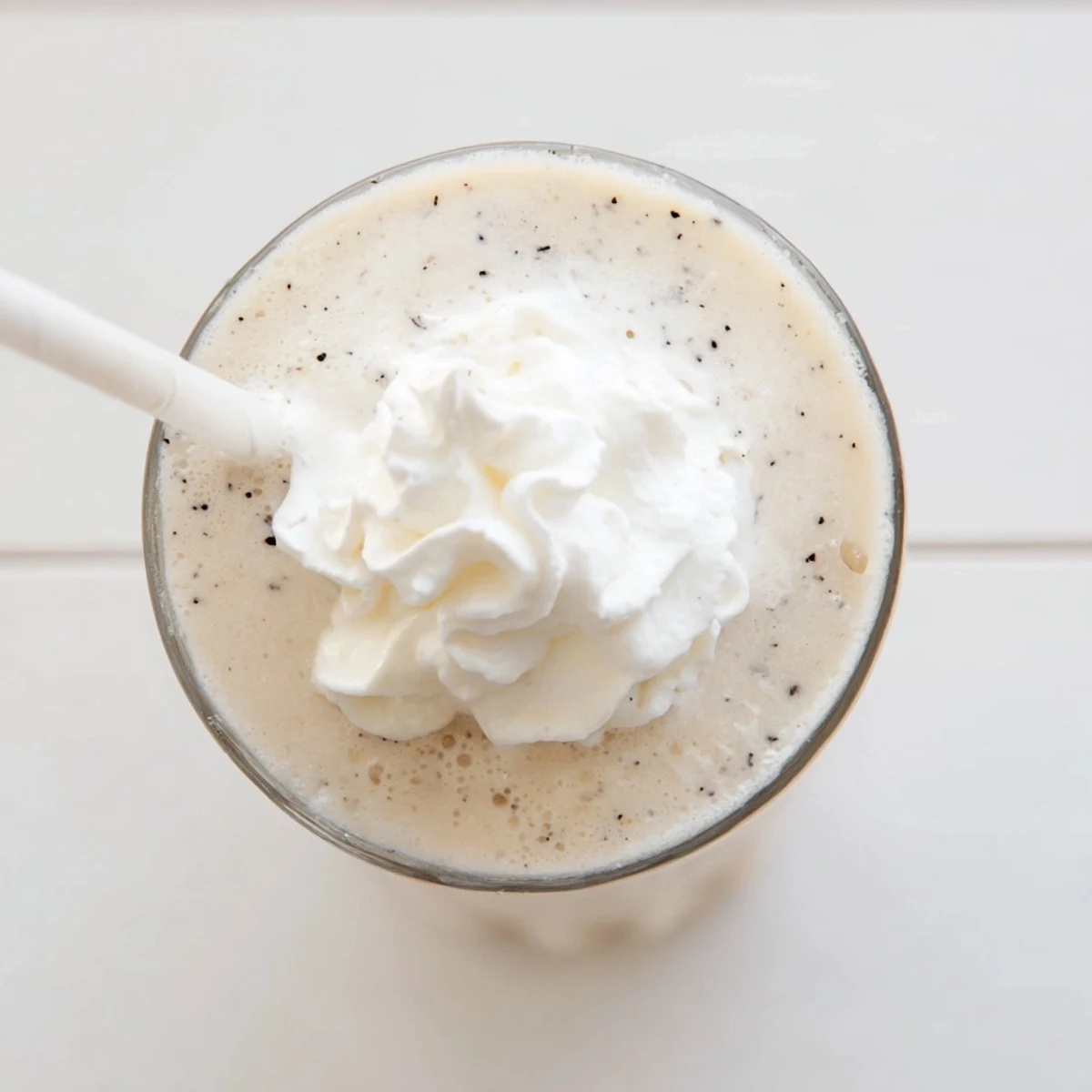 Creamy Vanilla Bean Frappuccino with whipped cream topping in a tall glass for a refreshing treat.