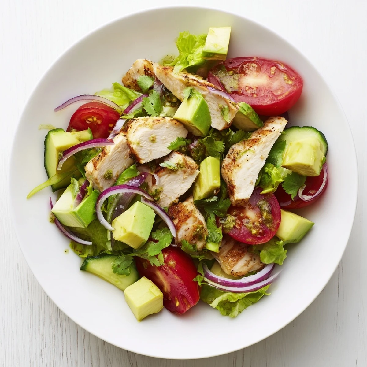 Sliced avocado and tender chicken tossed with crisp veggies, making Avocado Chicken Salad for a healthy lunch.