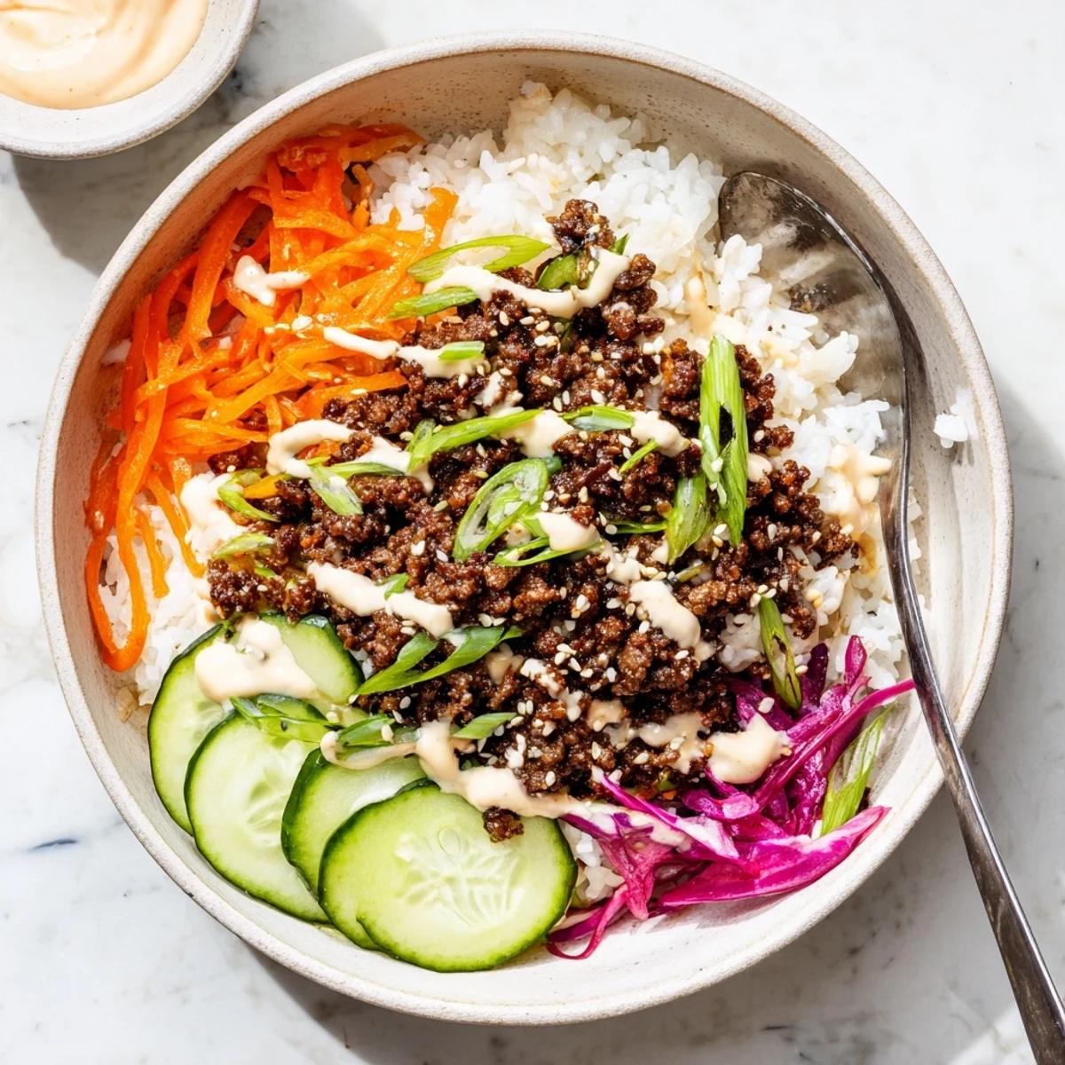 Serving suggestion for Korean Beef Bowl with Spicy Mayo, garnished with green onions and sesame seeds, ready to enjoy for dinner.