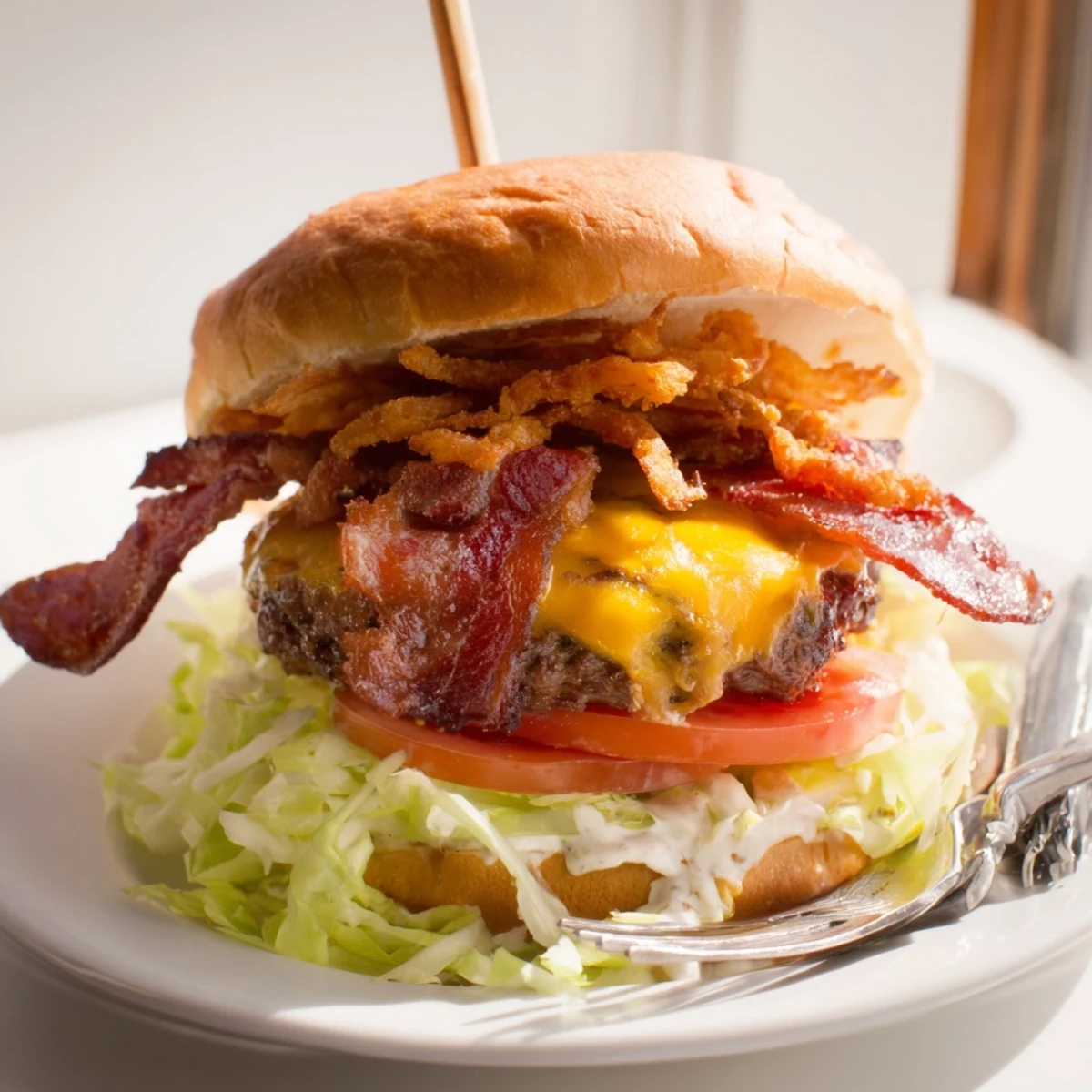 The creamy ranch sauce drips onto shredded lettuce and ripe tomato, ready to serve.