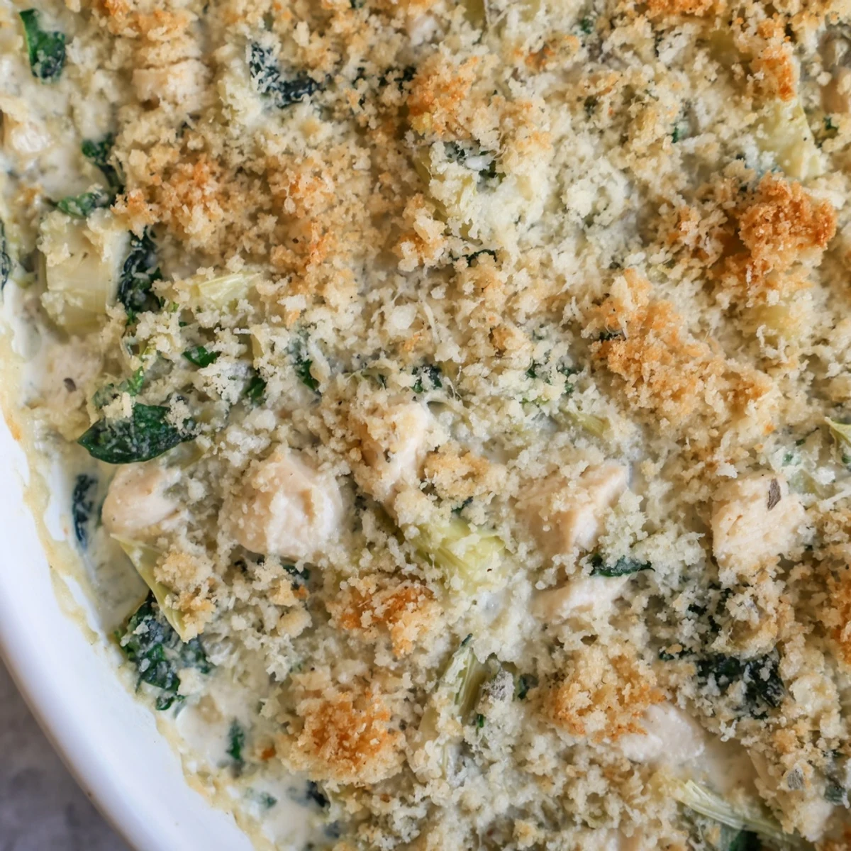 Hearty high protein casserole featuring melted cheese with tender chicken spinach and artichokes