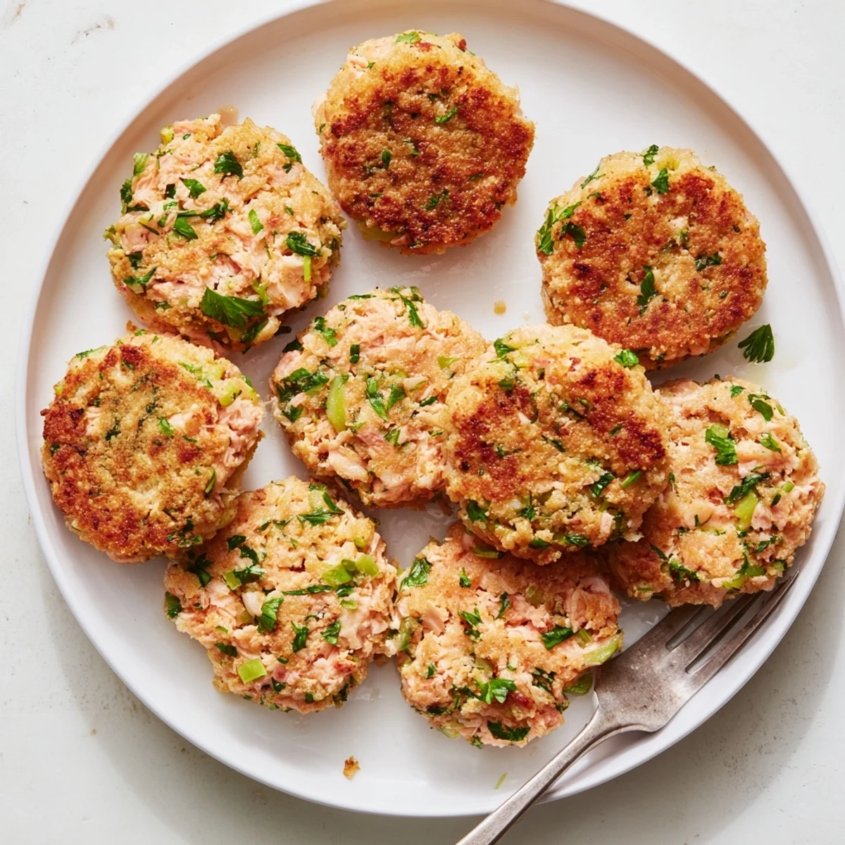 Homemade easy salmon cakes with canned salmon displaying tender flaky texture inside golden crust with tartar sauce