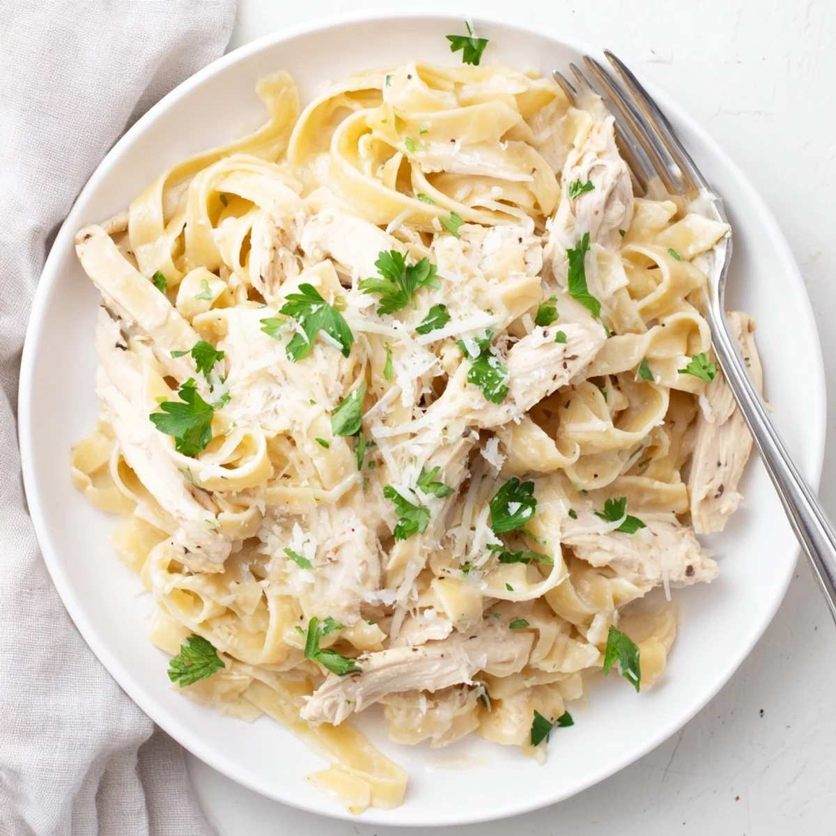 Creamy garlic parmesan chicken pasta with sliced chicken breasts and al dente noodles tossed in rich white sauce