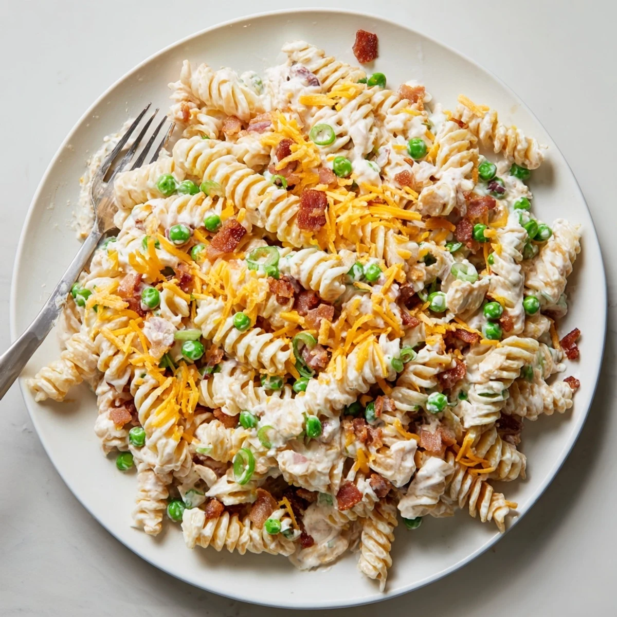Creamy crack pasta salad tossed with crispy bacon, sharp cheddar cheese, and green onions
