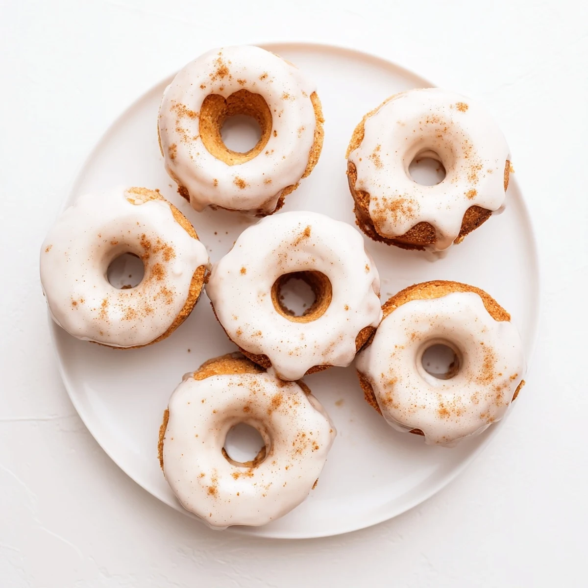 Golden baked Greek yogurt cake donuts topped with sweet vanilla glaze and sprinkles