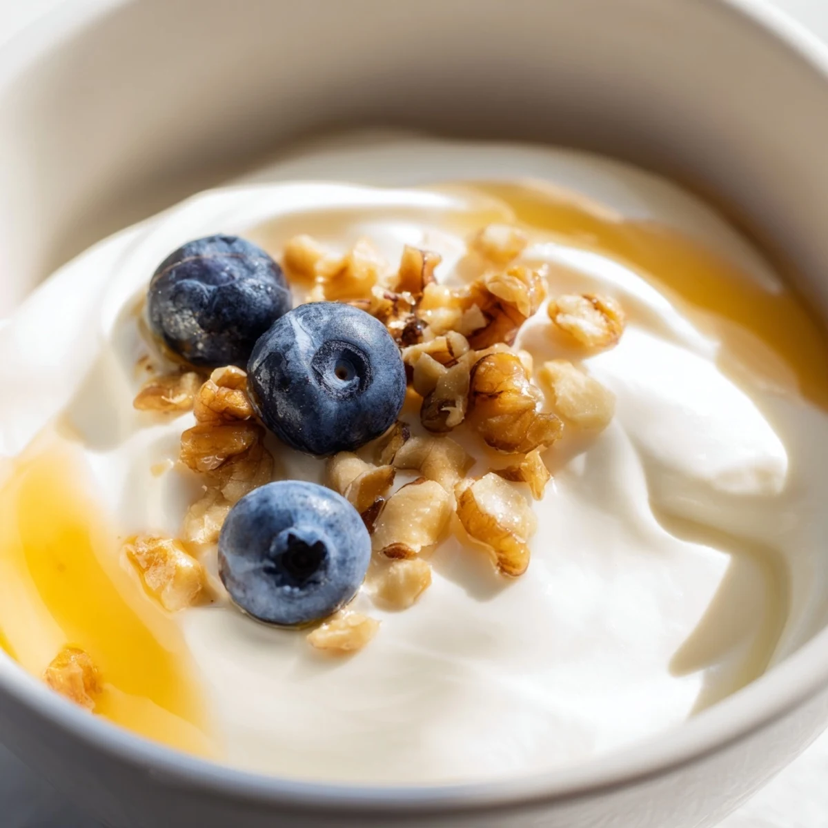 Creamy homemade Greek yogurt bowl topped with fresh berries, honey, and granola