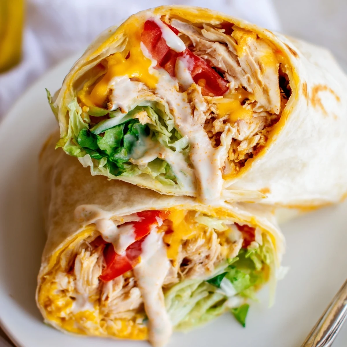 Cheesy Garlic Chicken Wraps steaming on a plate, melted cheese stretching  