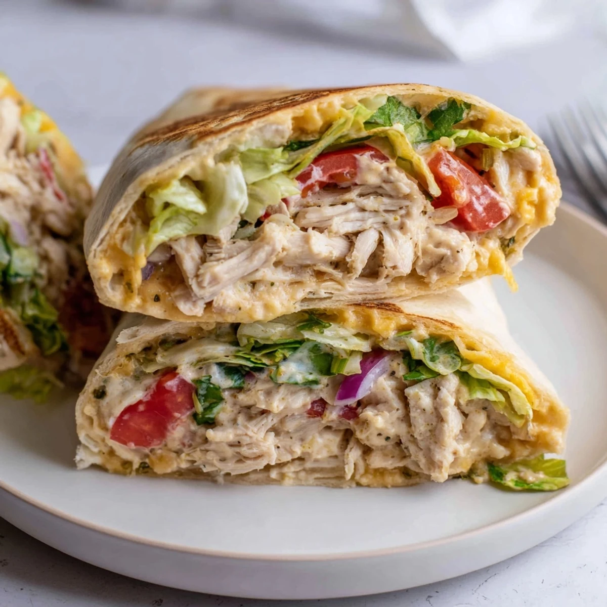 Family-style Cheesy Garlic Chicken Wraps drizzled with tangy mayo sauce, vibrant veggies