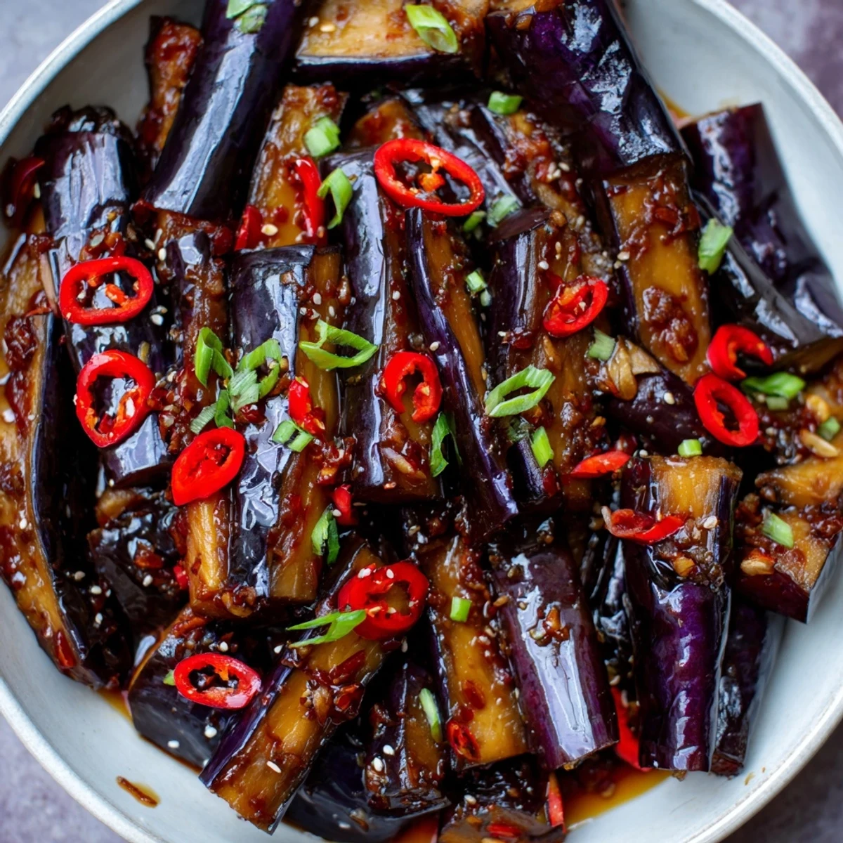 Sichuan Style Braised Aubergines glistening in spicy red sauce with scallions