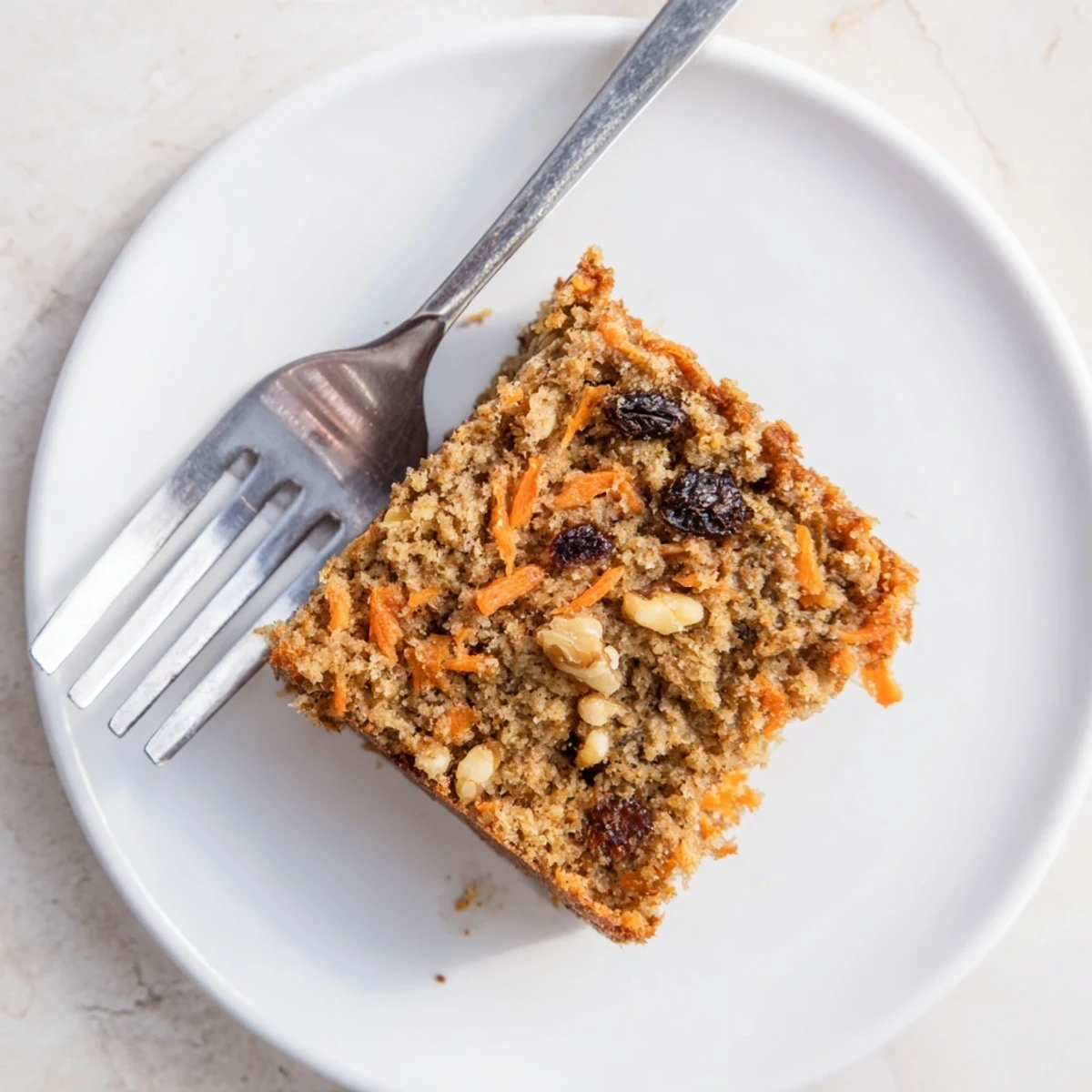 Wholesome flourless carrot cake square featuring spiced oat crumb and sweet carrot flecks