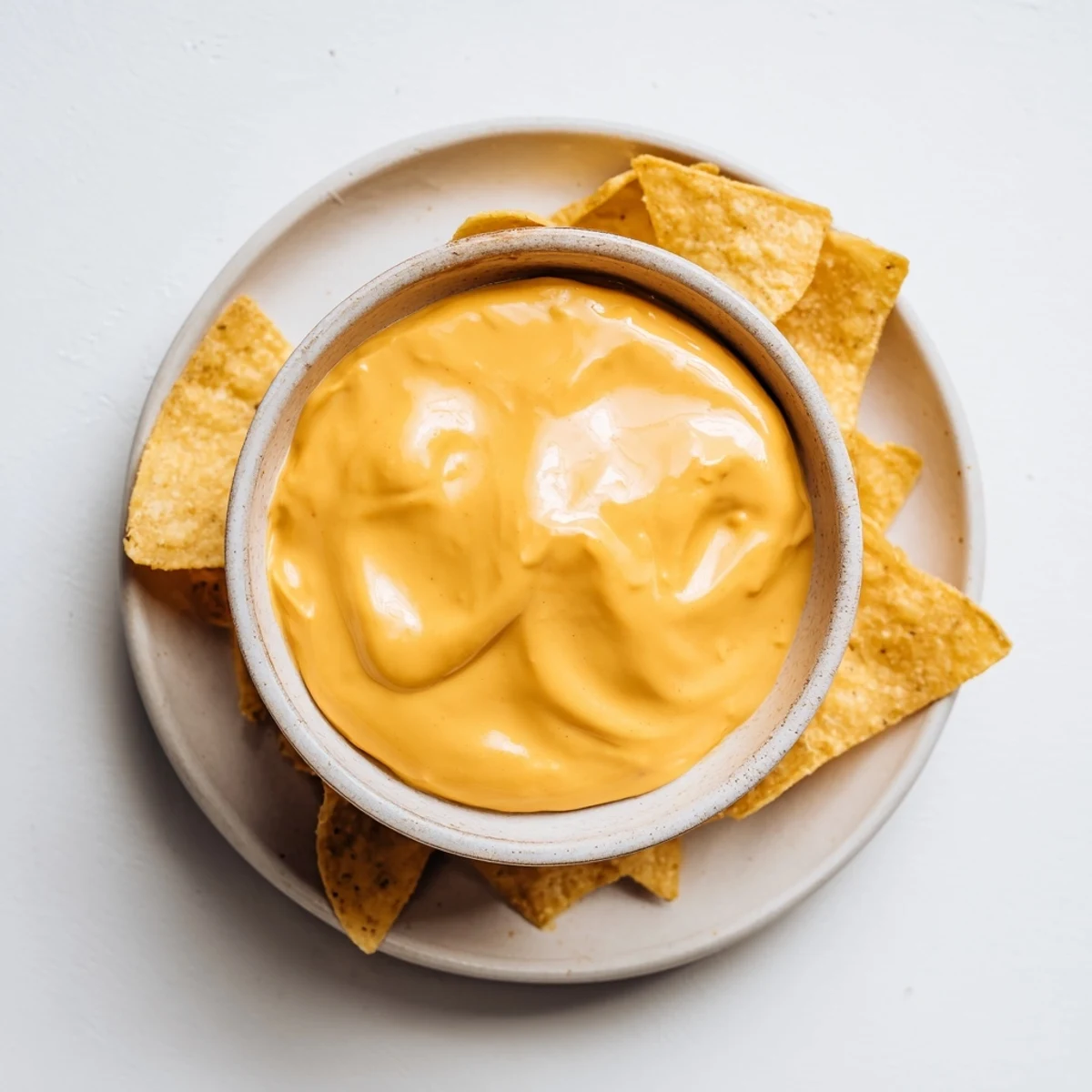 Smooth and spicy nacho cashew cheese sauce poured over loaded nachos with vibrant toppings