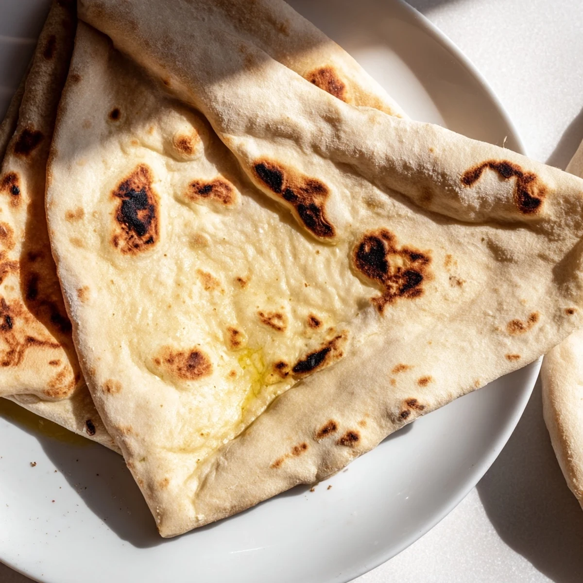 Golden Turkish Bazlama flatbread with pillowy soft interior and lightly charred surface