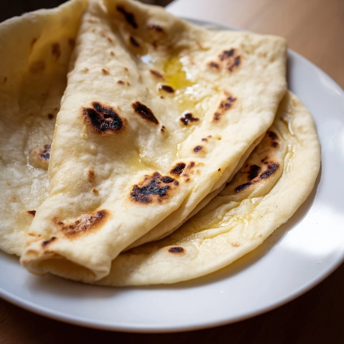 Turkish Bazlama bread fresh from skillet, brushed with butter and stacked warm