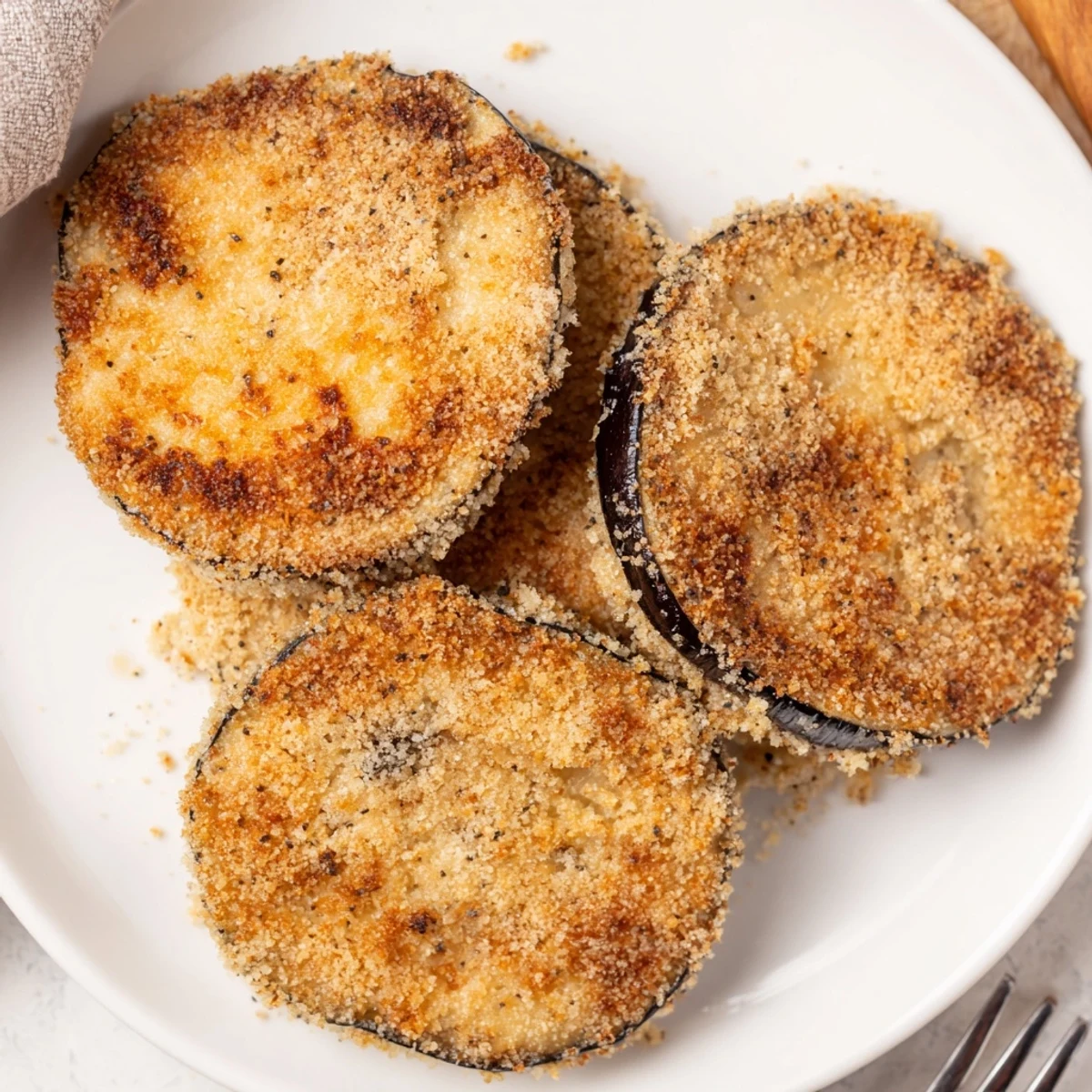 Crispy Baked Eggplant layered on platter, sprinkled Parmesan, perfect appetizer