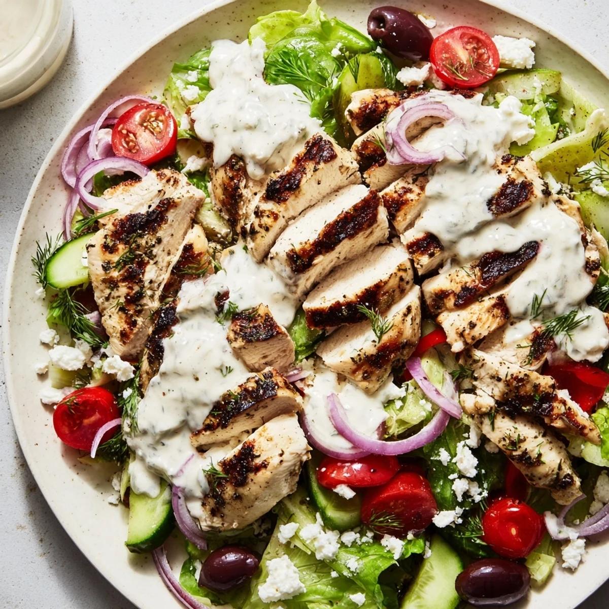 Greek Chicken Salad with Creamy Whipped Feta Dressing piled on a rustic white platter