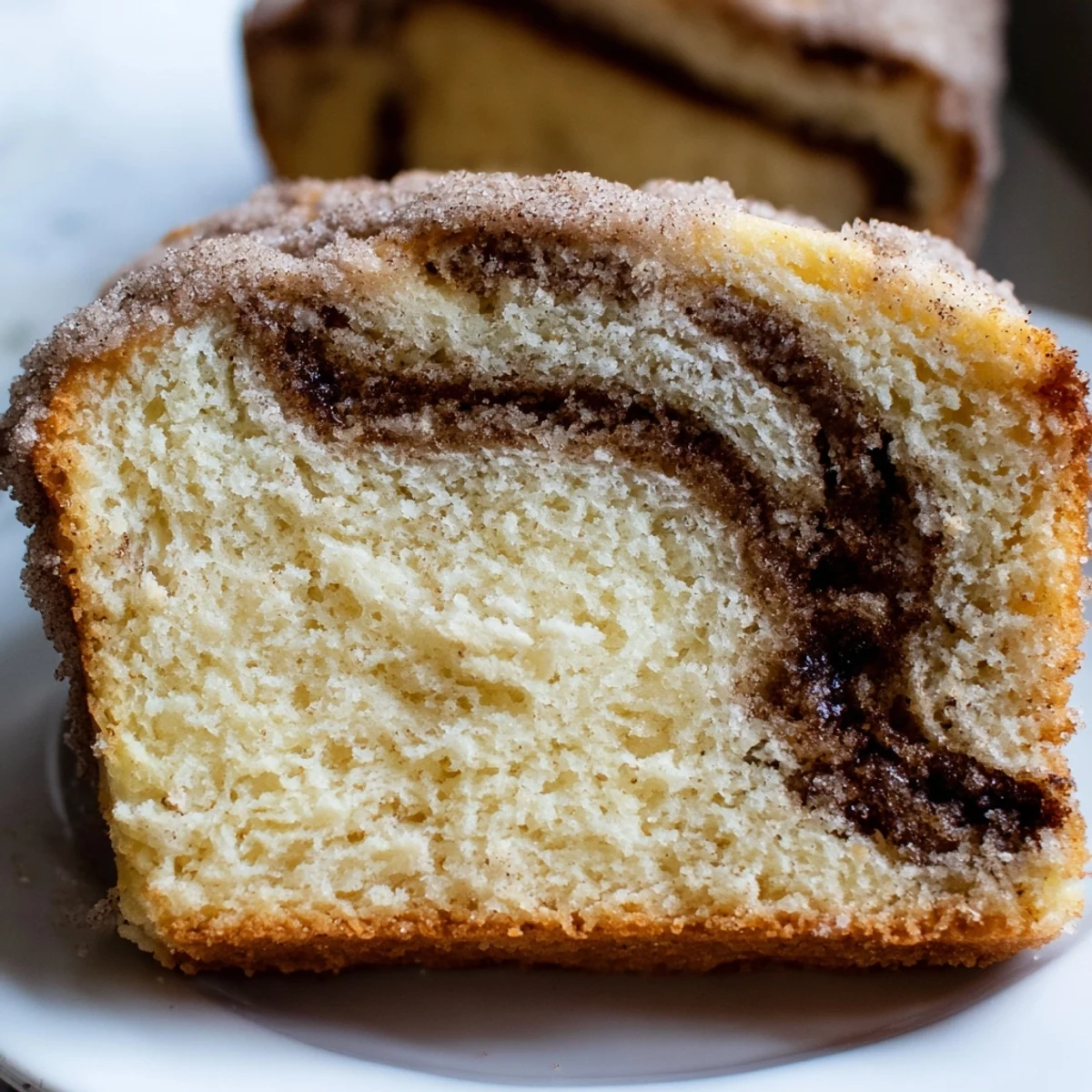 Warm cinnamon donut loaf sliced thick with a golden cinnamon sugar crust